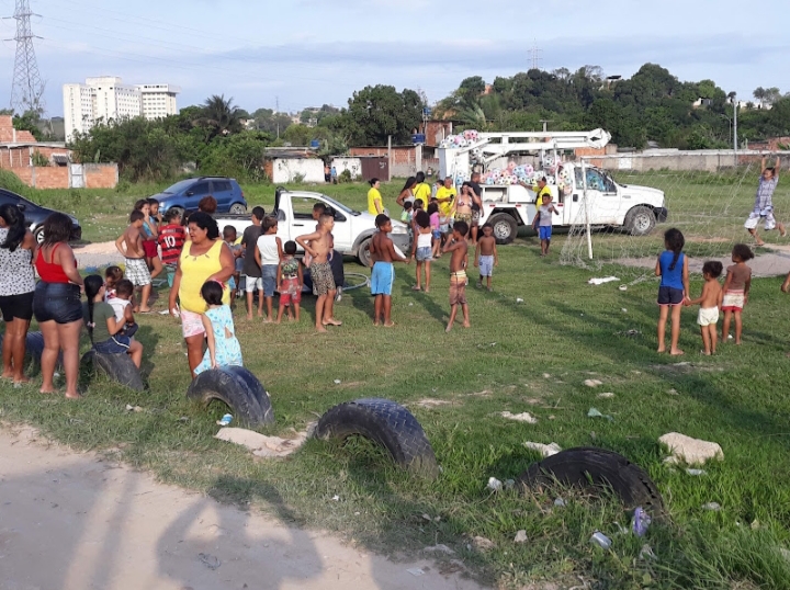 Crianças e famílias reunidas em um campo durante a Festa do Dia das Crianças